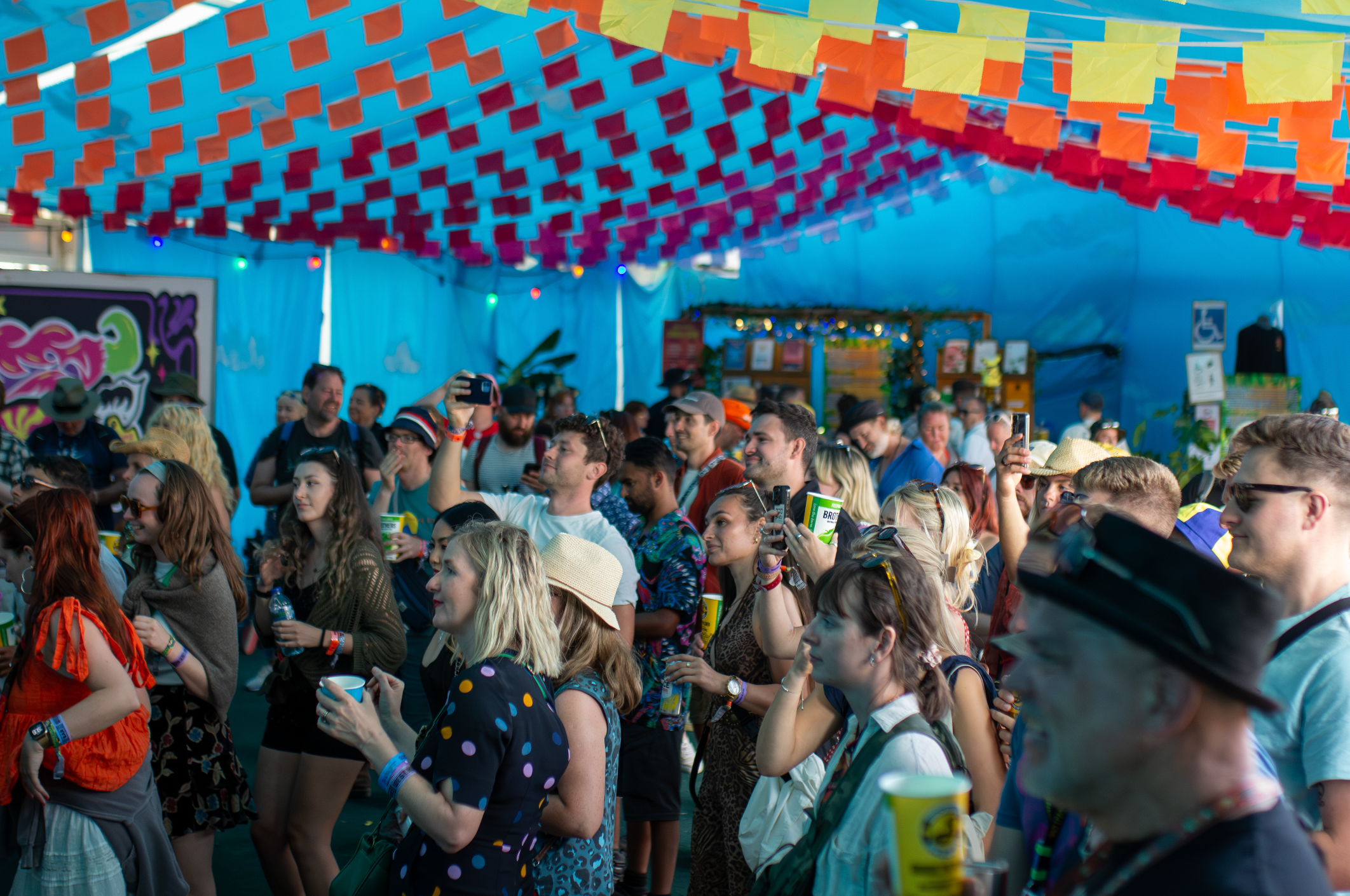 A lively crowd beneath colourful festival decorations
