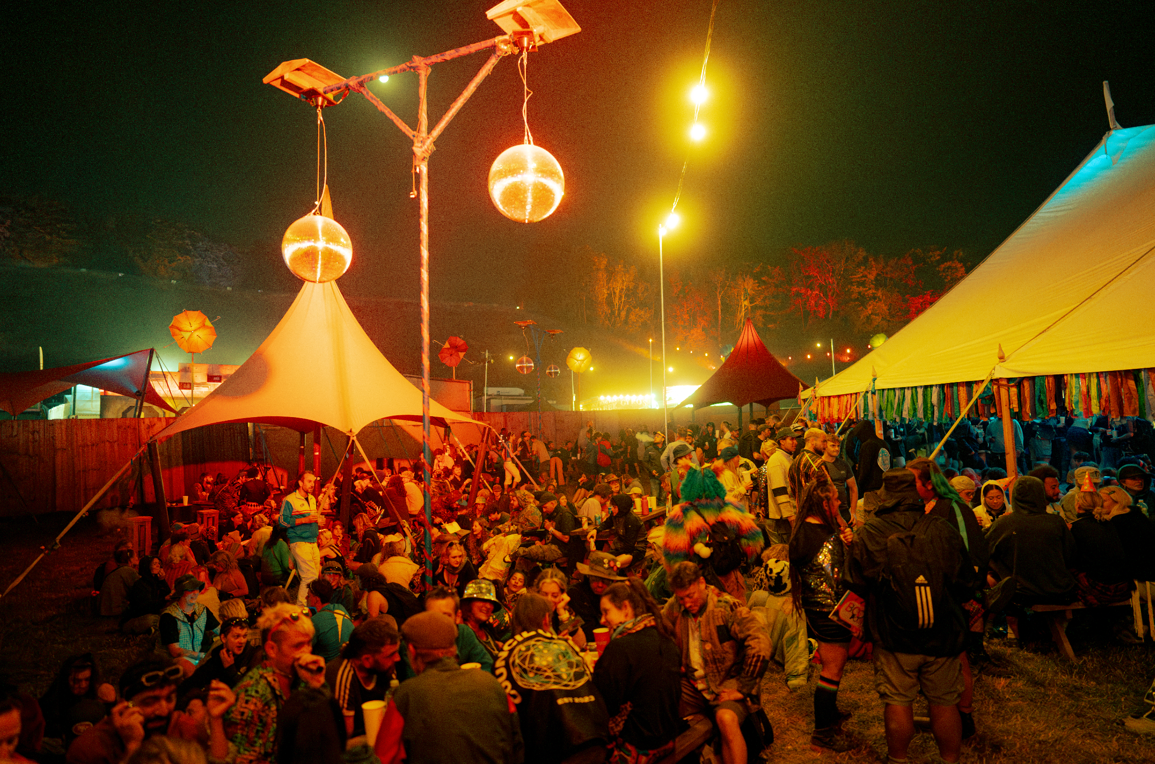 Guests enjoying an outdoor festival bar at night