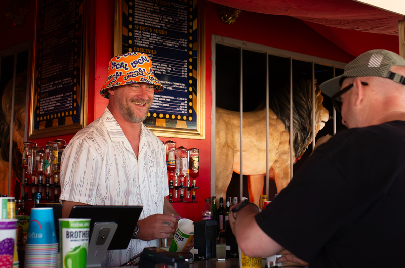 A smiling bartender serving a guest